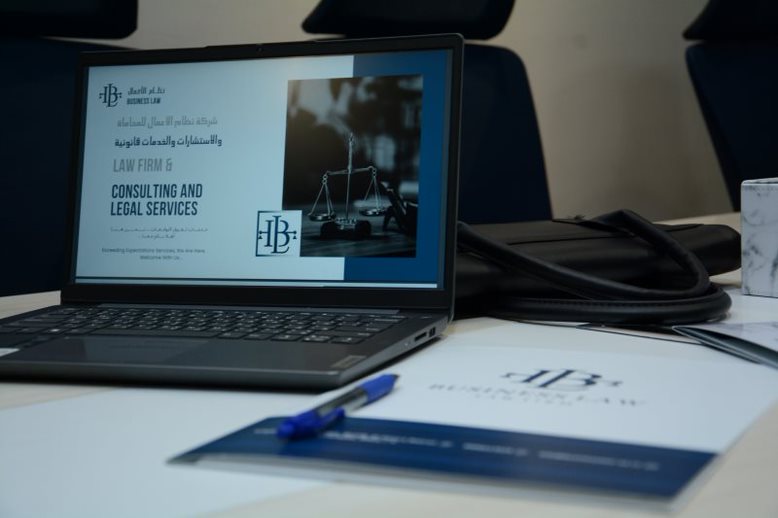 Laptop showing a Business Law consulting and legal services presentation beside branded papers