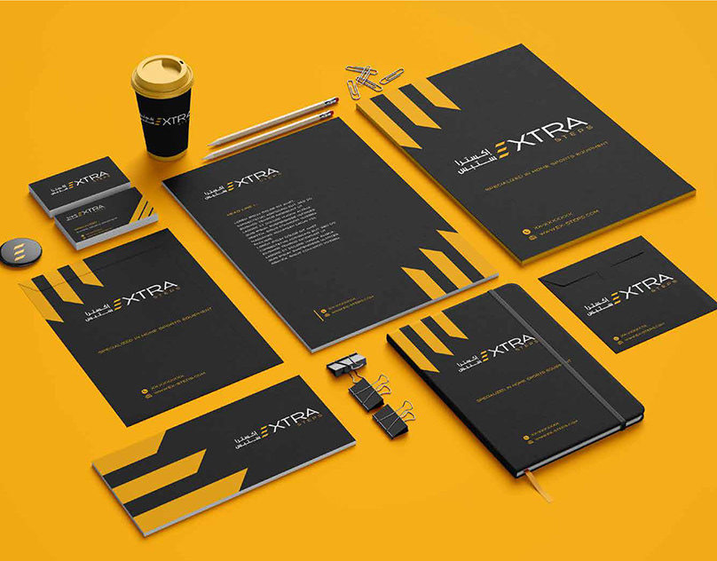 Extra Steps stationery set in black with yellow accents, including letterheads, business cards and a notebook on yellow