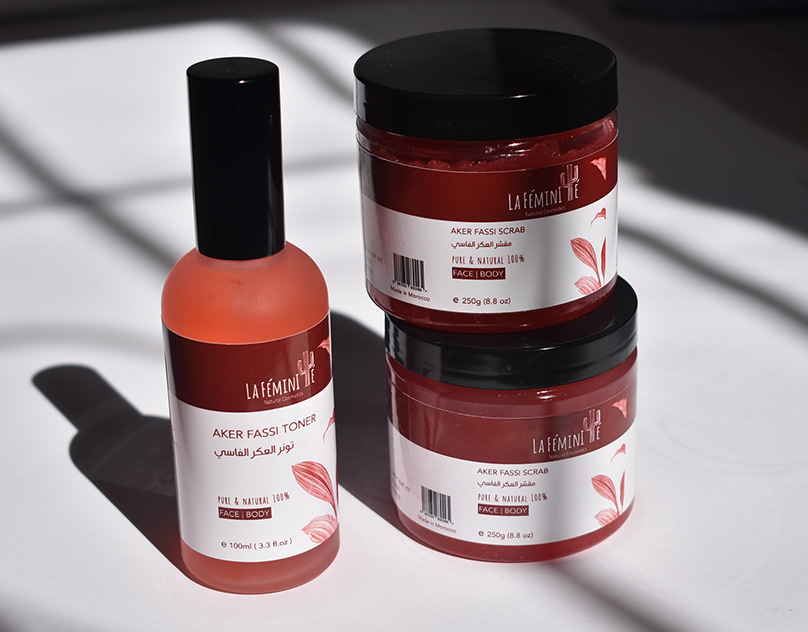 Lafeminite natural cosmetics toner bottle and scrub jars with red and white labels in soft window light