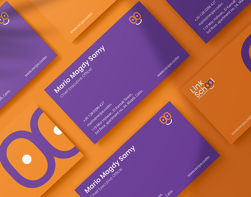 Purple Link School business cards with orange double-o graphics arranged on an orange background